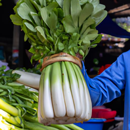 Một người cầm một bó rau cải cúc tươi ngon tại chợ địa phương.